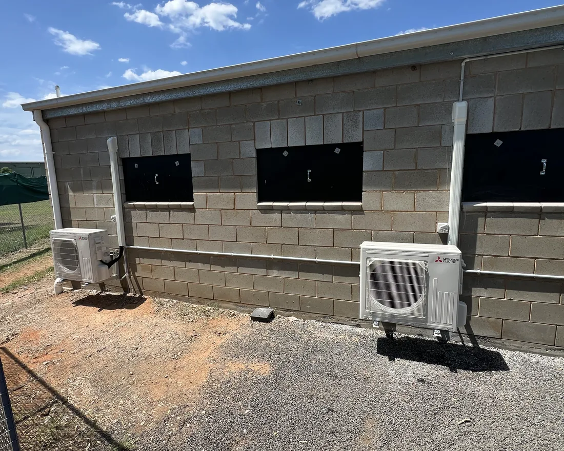 Two split-system condensers mounted on a commercial block building
