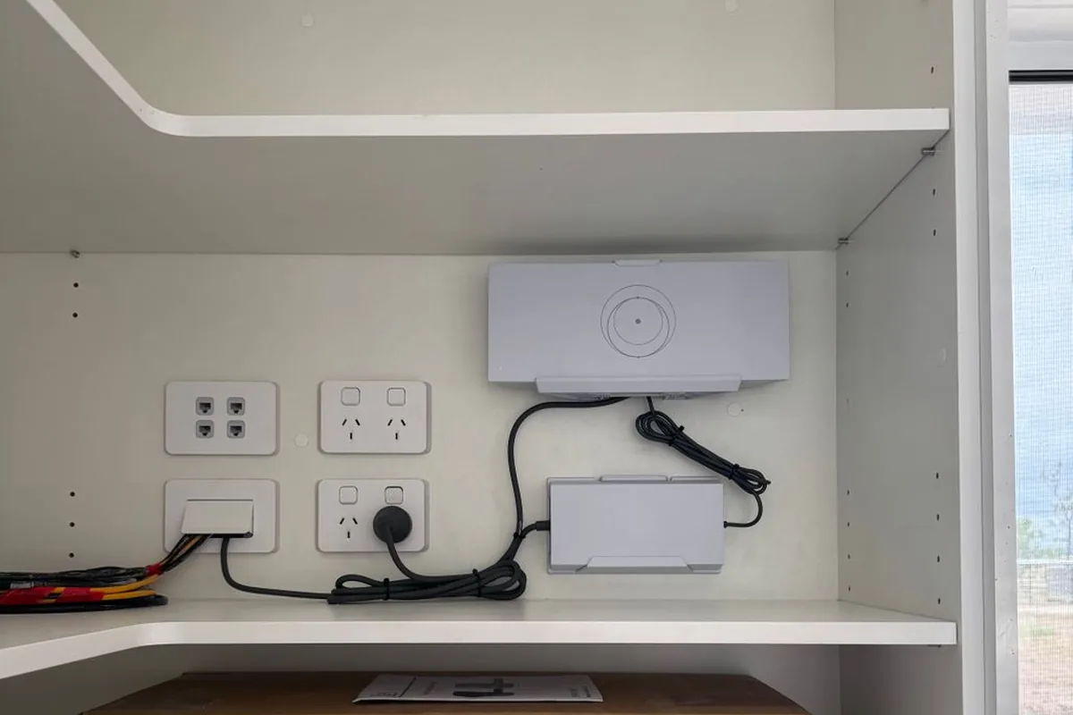 A comms cupboard with a wireless access point, outlets and data points fitted