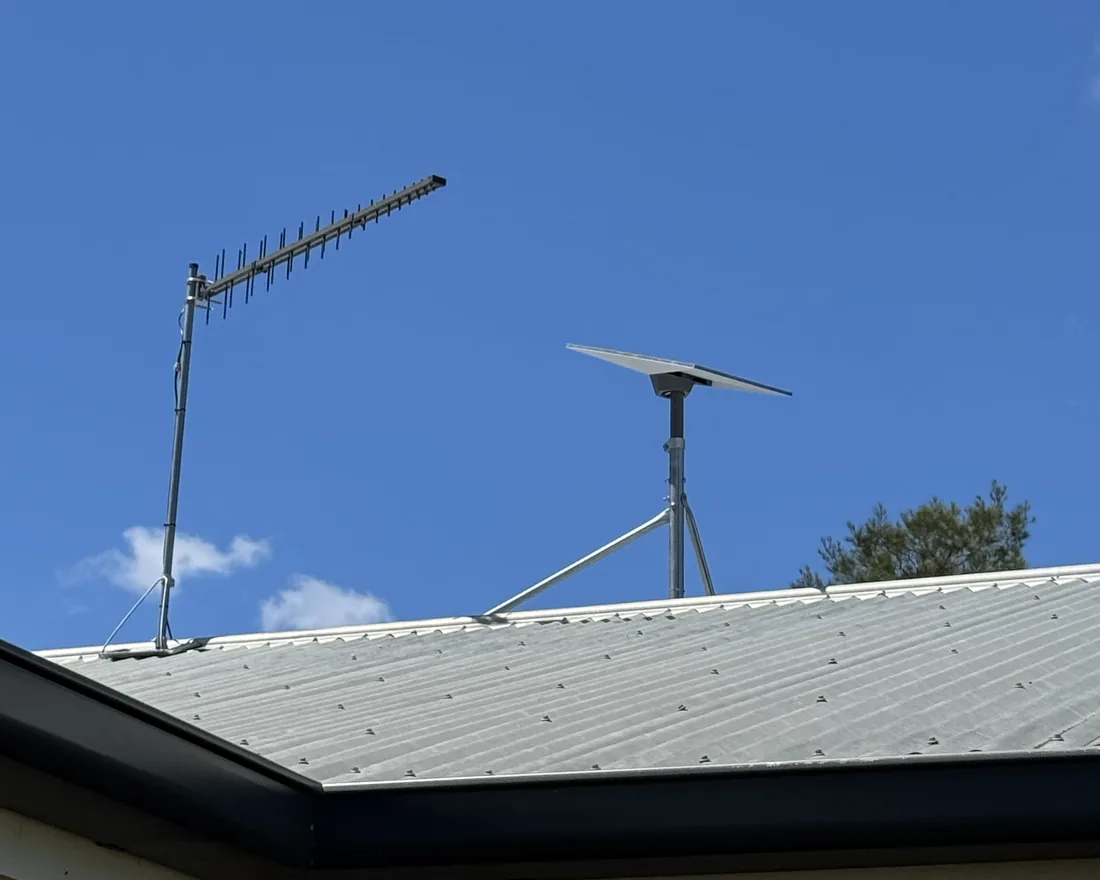 A Starlink dish and yagi antenna mounted on a house roofline